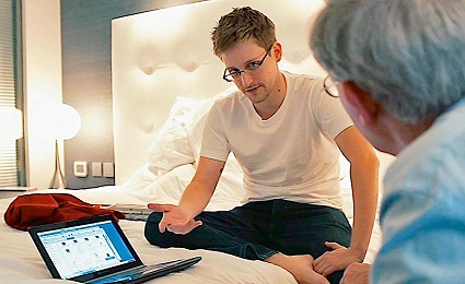 Snowden sitting on bed sharing info